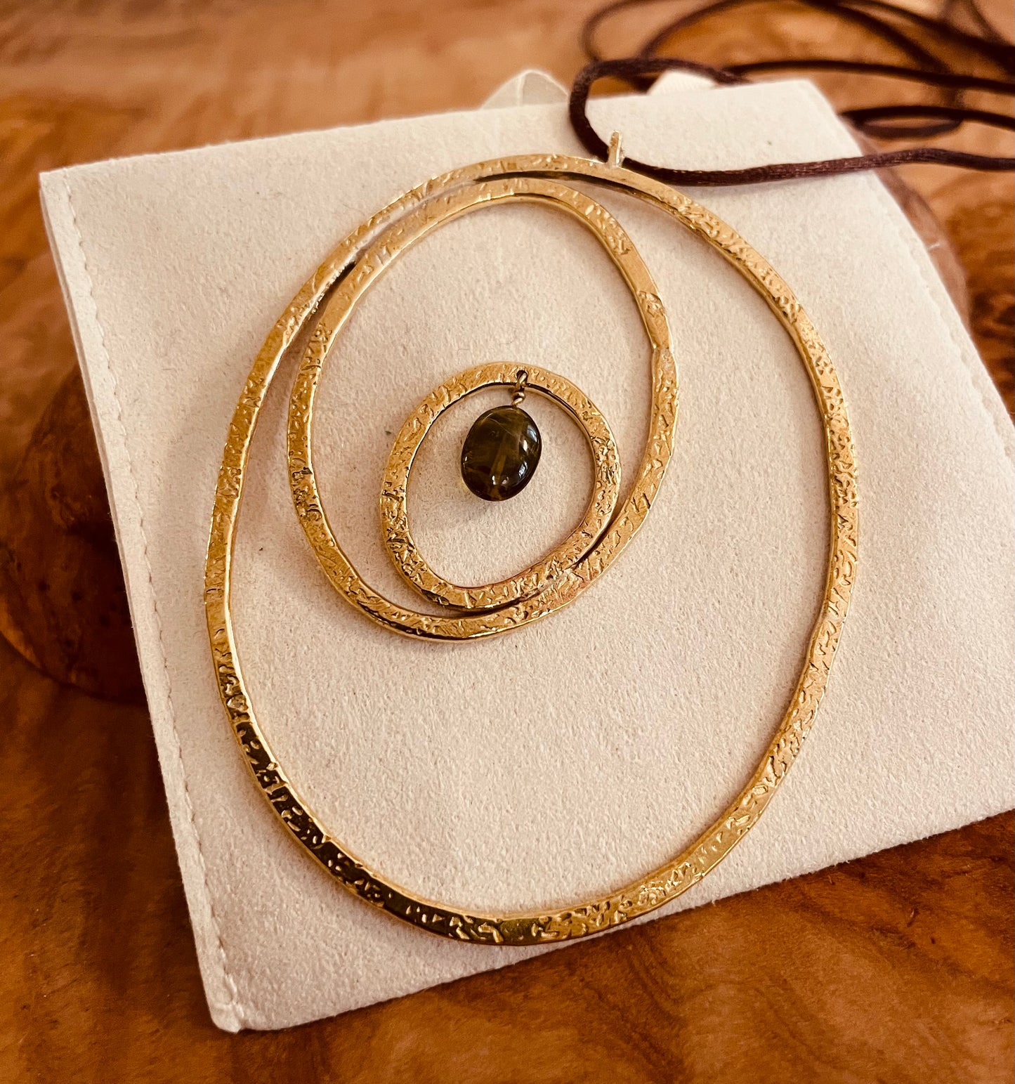 "Silenzi in orbita... Nelle orbite vuote, stelle di silenzio, tracce di un passato che sfugge e ritorna."  -   Linea 'Orbite': ciondolo, orecchini e anello in ottone martellato con tormalina.