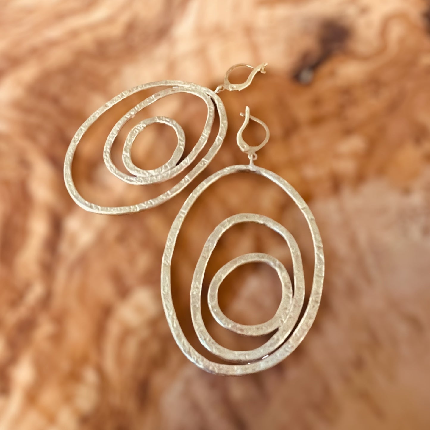 "Silenzi in orbita... Nelle orbite vuote, stelle di silenzio, tracce di un passato che sfugge e ritorna."  -   Linea 'Orbite': ciondolo, orecchini e anello in ottone martellato con tormalina.