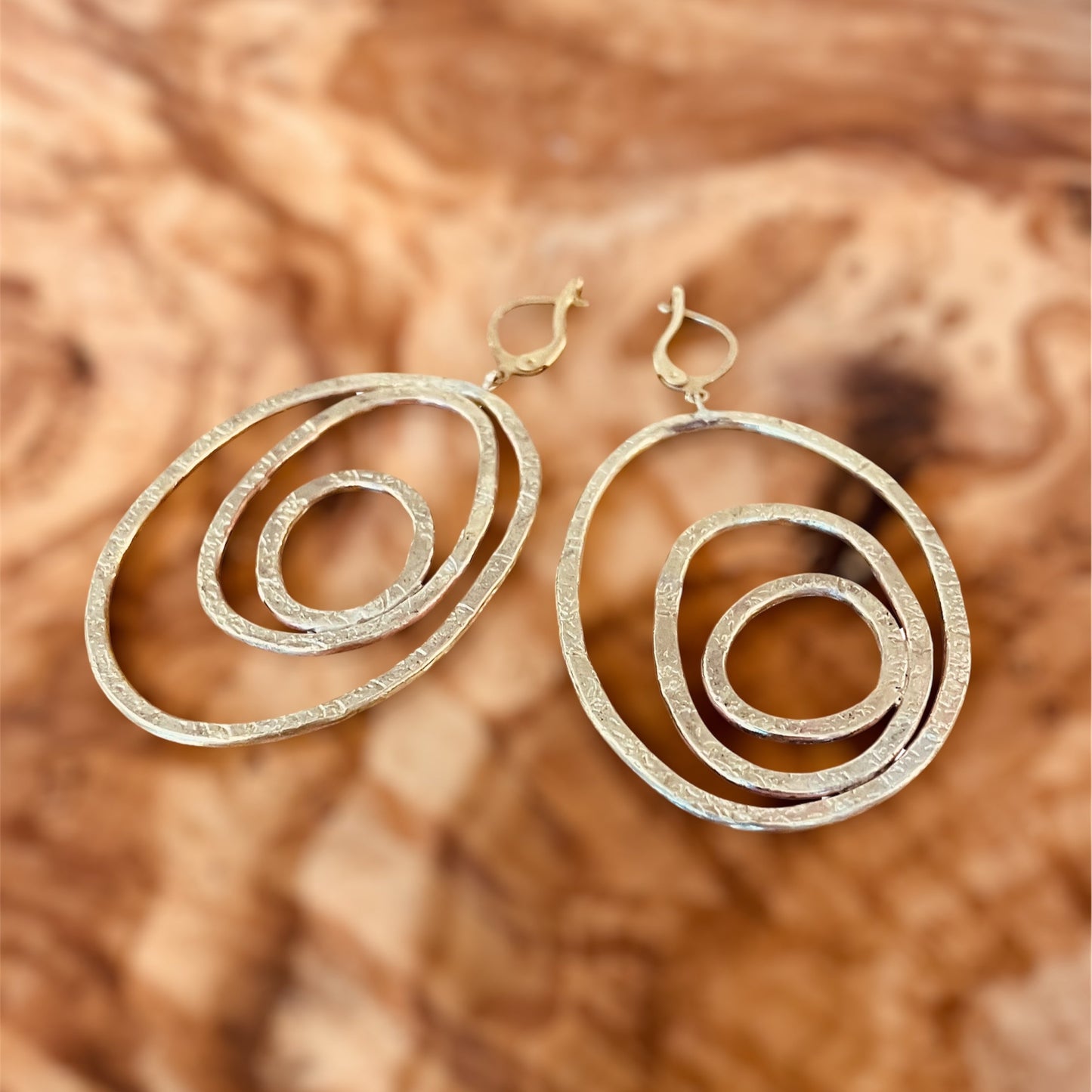 "Silenzi in orbita... Nelle orbite vuote, stelle di silenzio, tracce di un passato che sfugge e ritorna."  -   Linea 'Orbite': ciondolo, orecchini e anello in ottone martellato con tormalina.