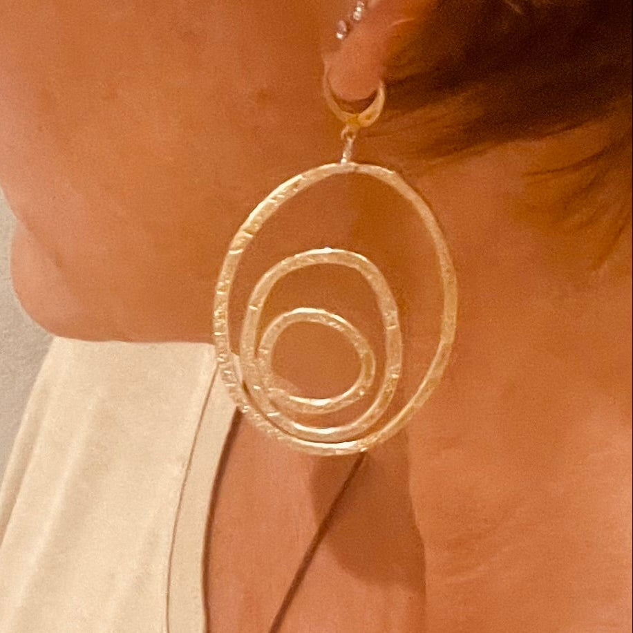 "Silenzi in orbita... Nelle orbite vuote, stelle di silenzio, tracce di un passato che sfugge e ritorna."  -   Linea 'Orbite': ciondolo, orecchini e anello in ottone martellato con tormalina.