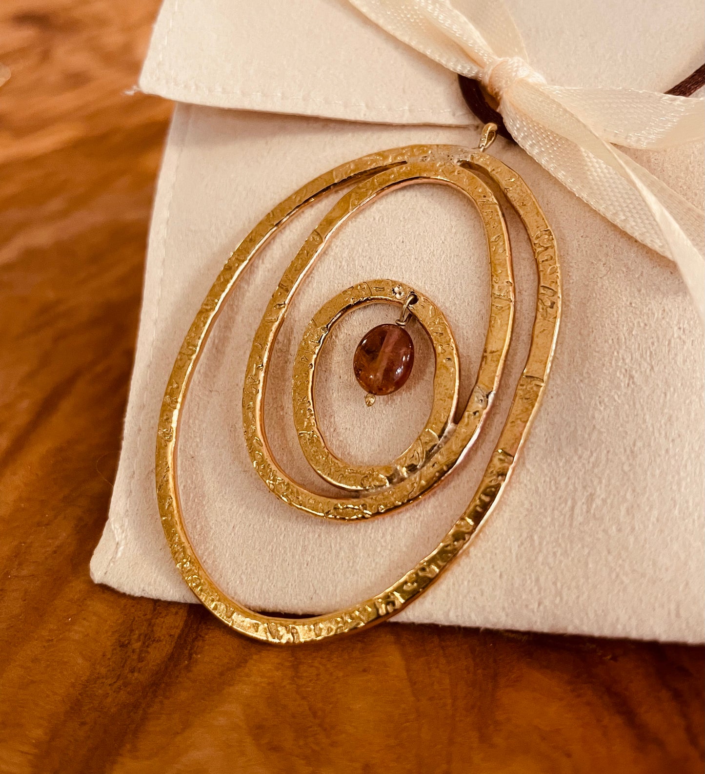 "Silenzi in orbita... Nelle orbite vuote, stelle di silenzio, tracce di un passato che sfugge e ritorna."  -   Linea 'Orbite': ciondolo, orecchini e anello in ottone martellato con tormalina.