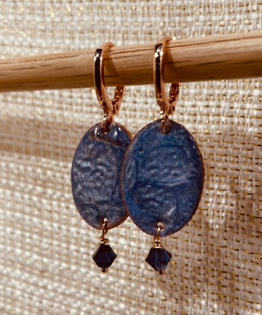 Copper pendant earrings embellished with small crystals.