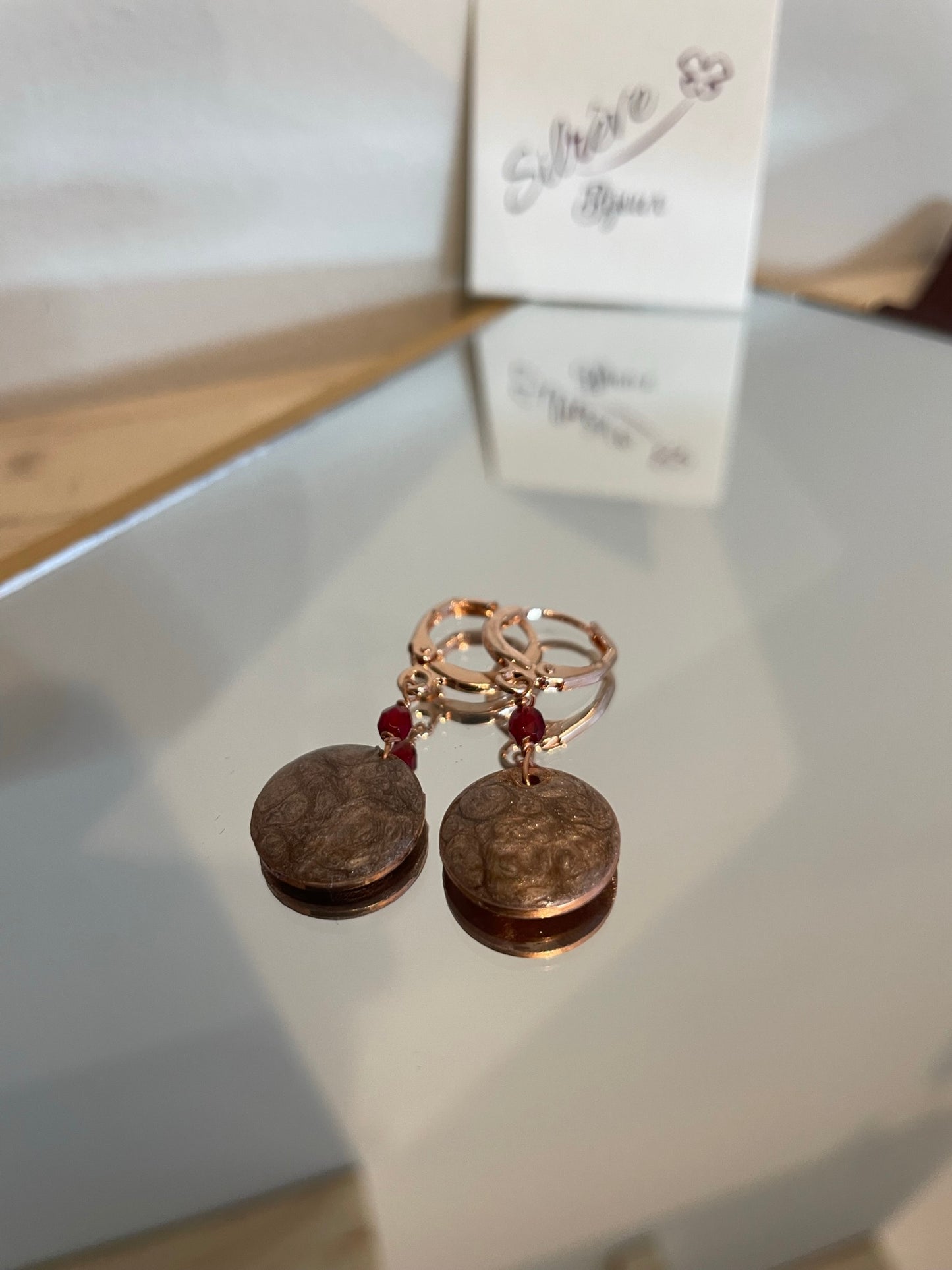 Copper pendant earrings embellished with small crystals.