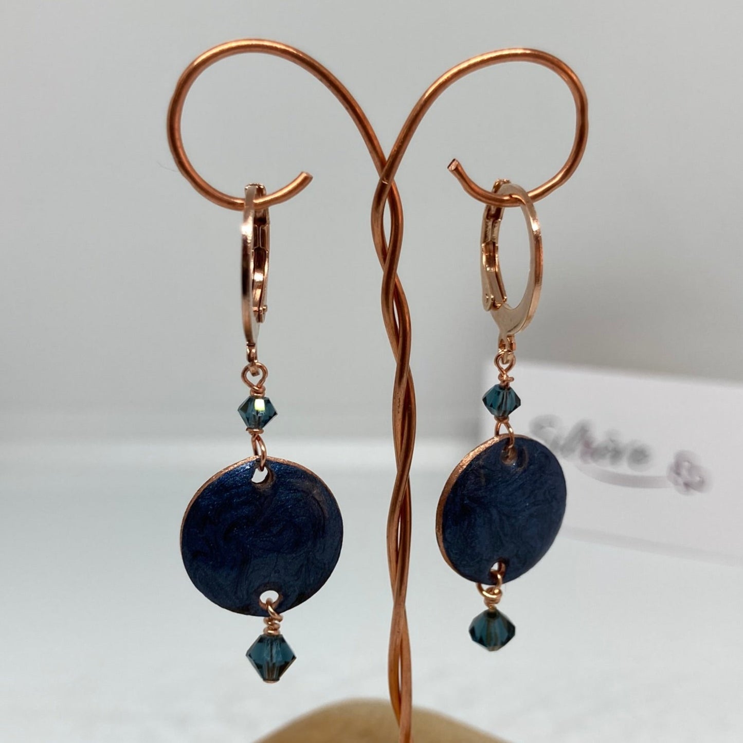 Copper pendant earrings embellished with small crystals.