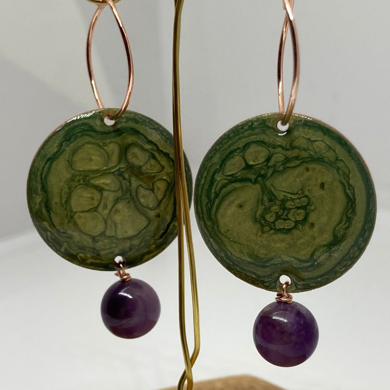 Copper pendant earrings embellished with amethyst beads.