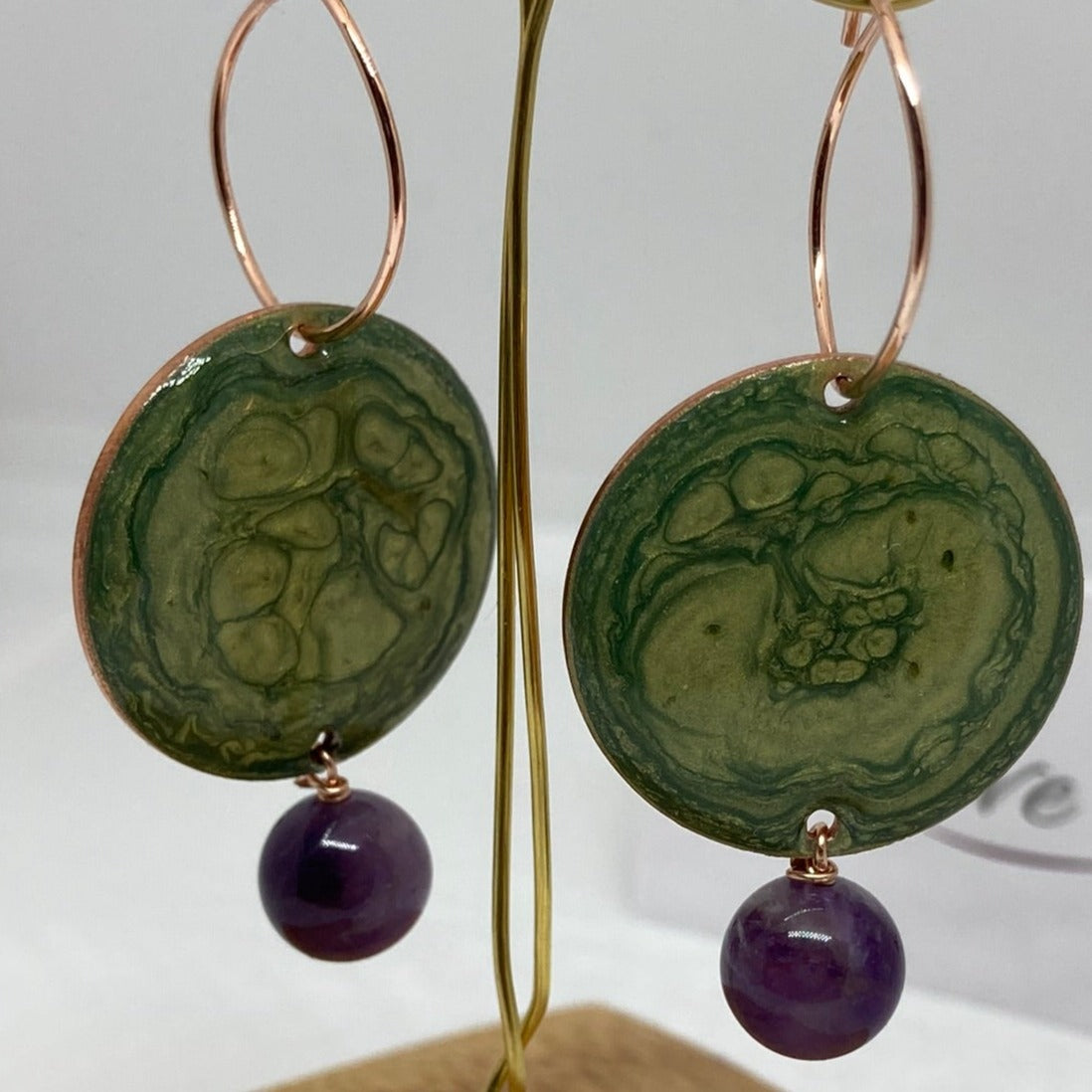 Copper pendant earrings embellished with amethyst beads.