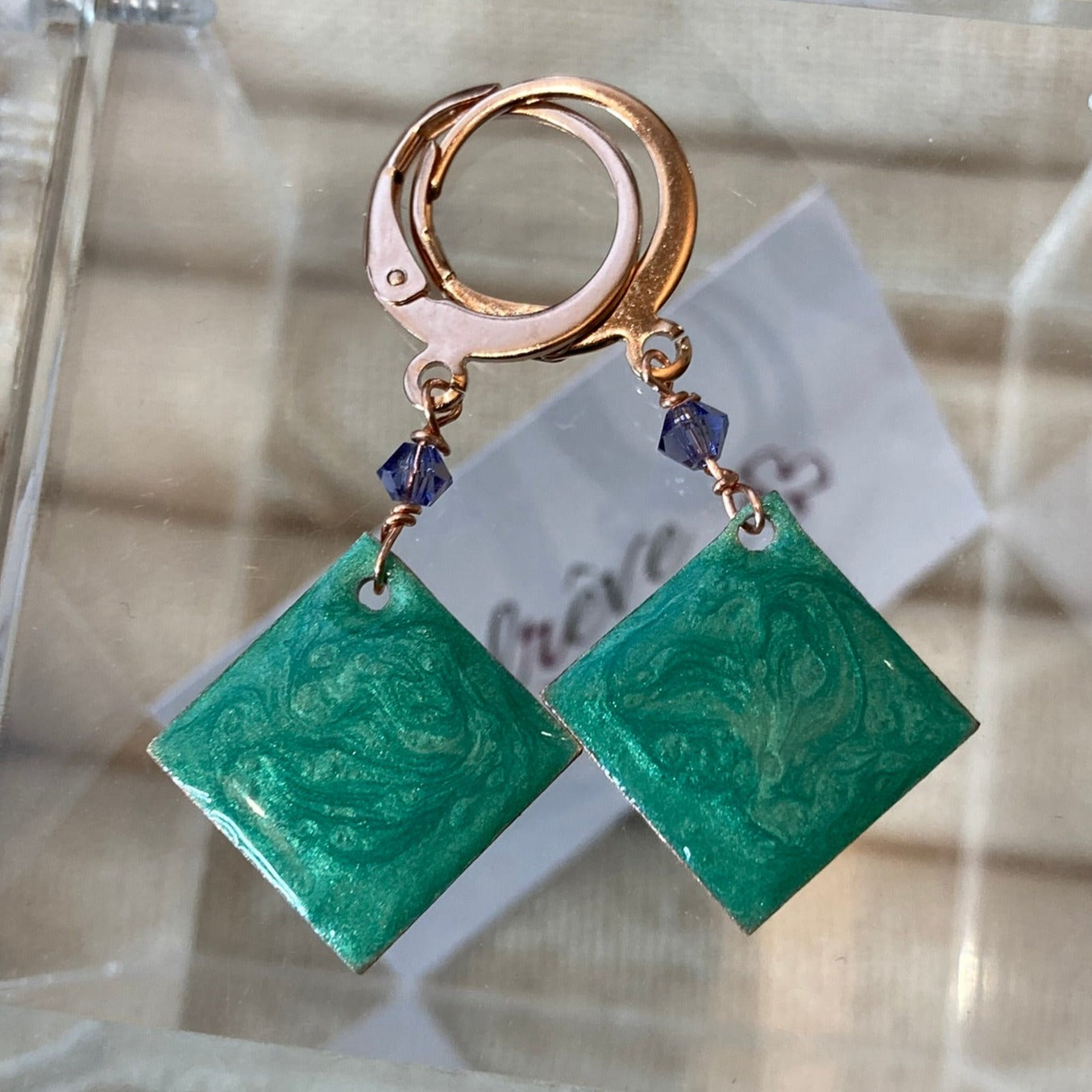 Copper pendant earrings embellished with small crystals.