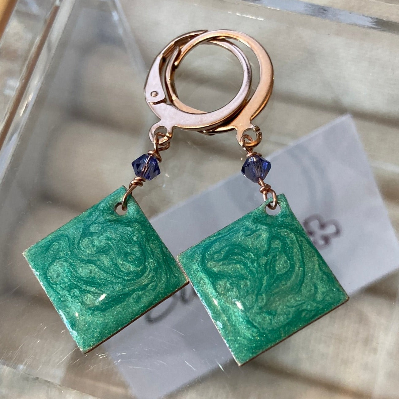 Copper pendant earrings embellished with small crystals.