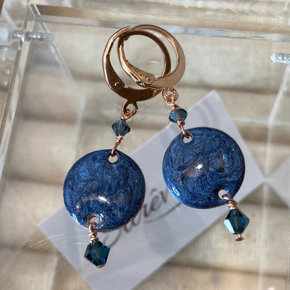 Copper pendant earrings embellished with small crystals.