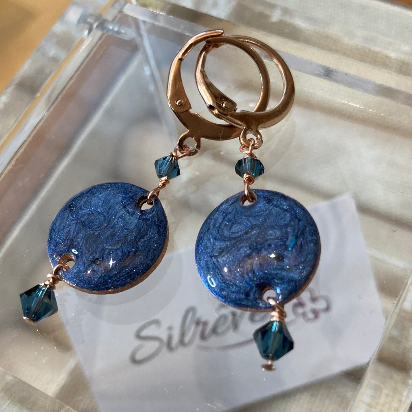 Copper pendant earrings embellished with small crystals.