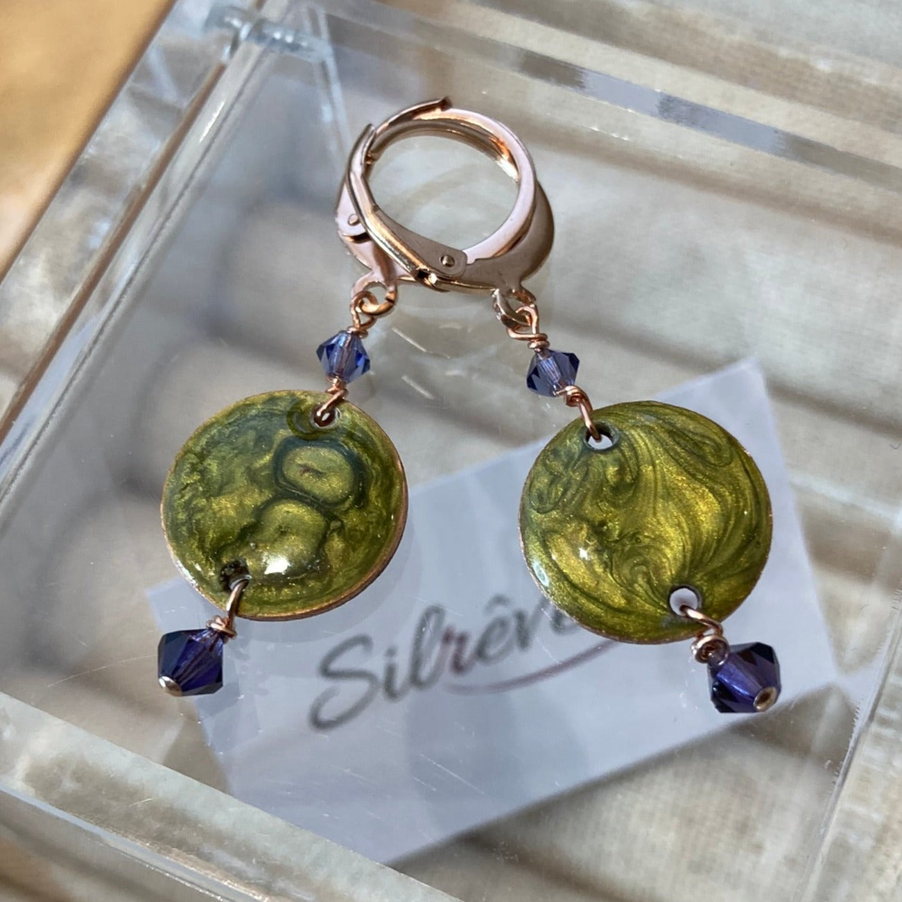 Copper pendant earrings embellished with small crystals.