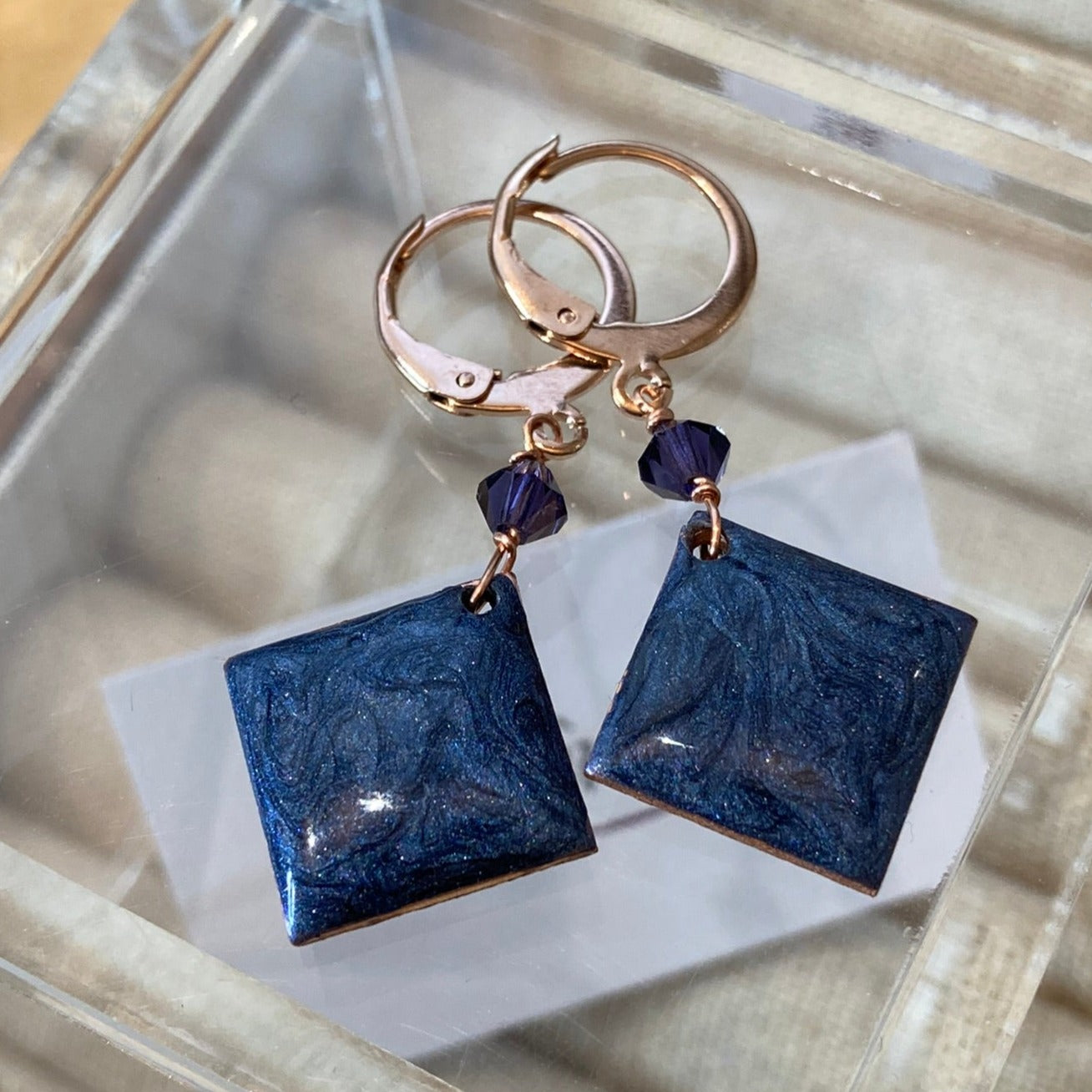 Copper pendant earrings embellished with small crystals.