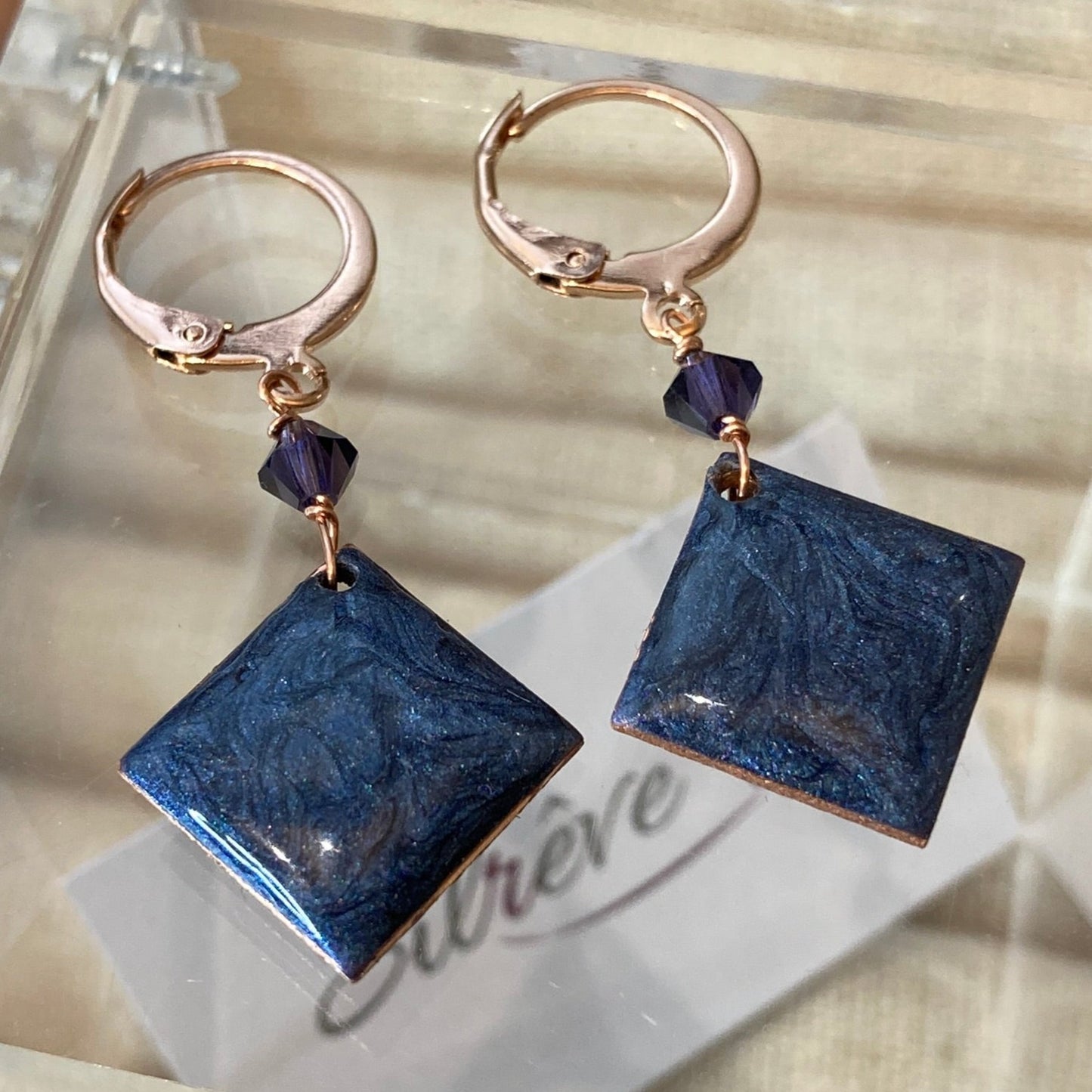 Copper pendant earrings embellished with small crystals.