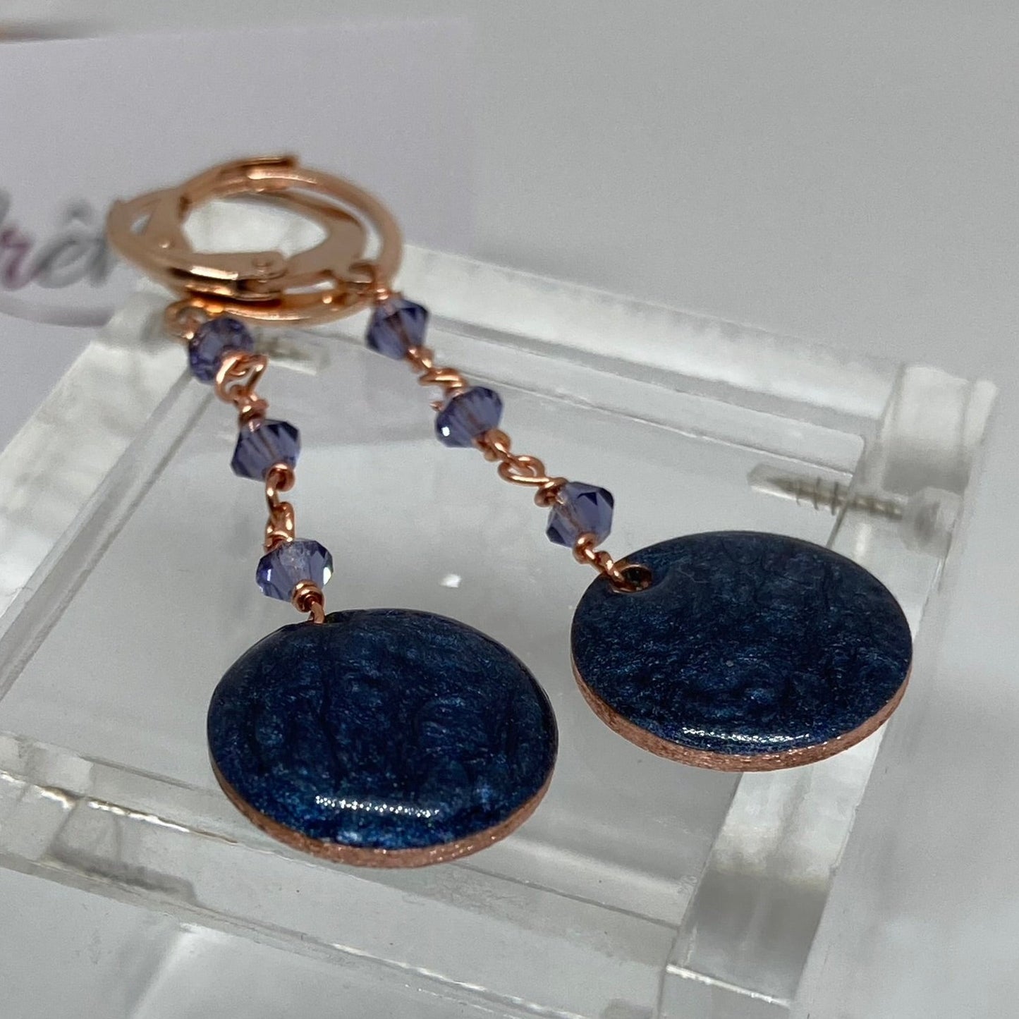 Copper pendant earrings embellished with small crystals.