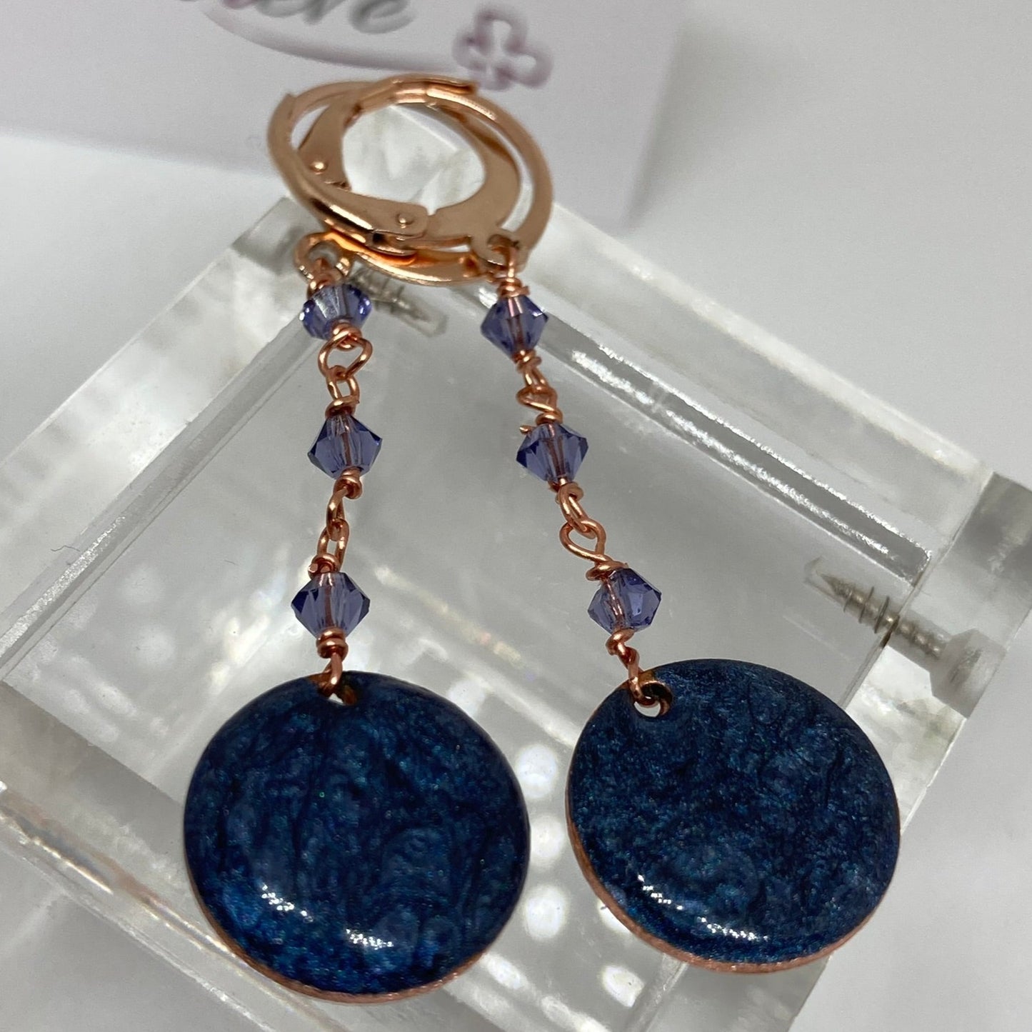 Copper pendant earrings embellished with small crystals.