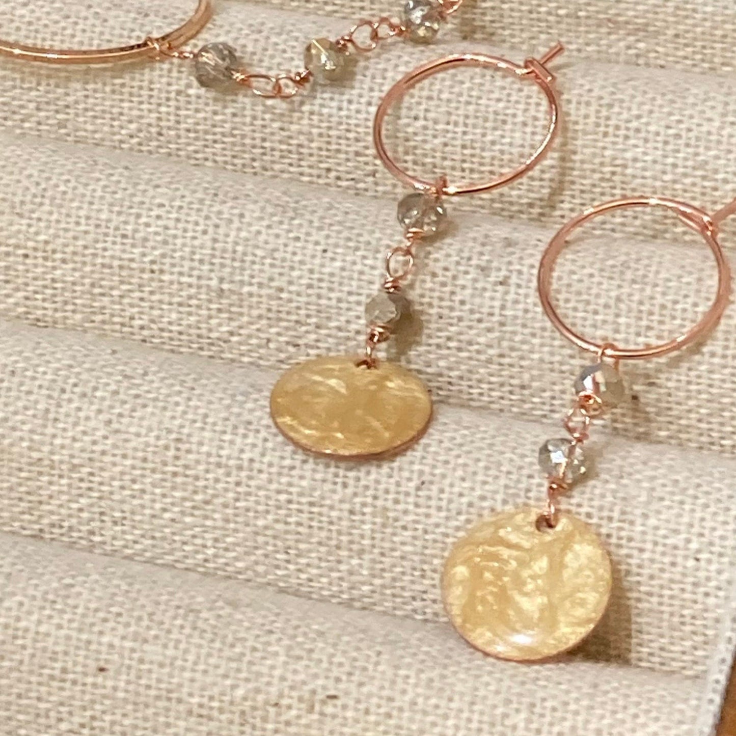 Copper pendant earrings embellished with small crystals.