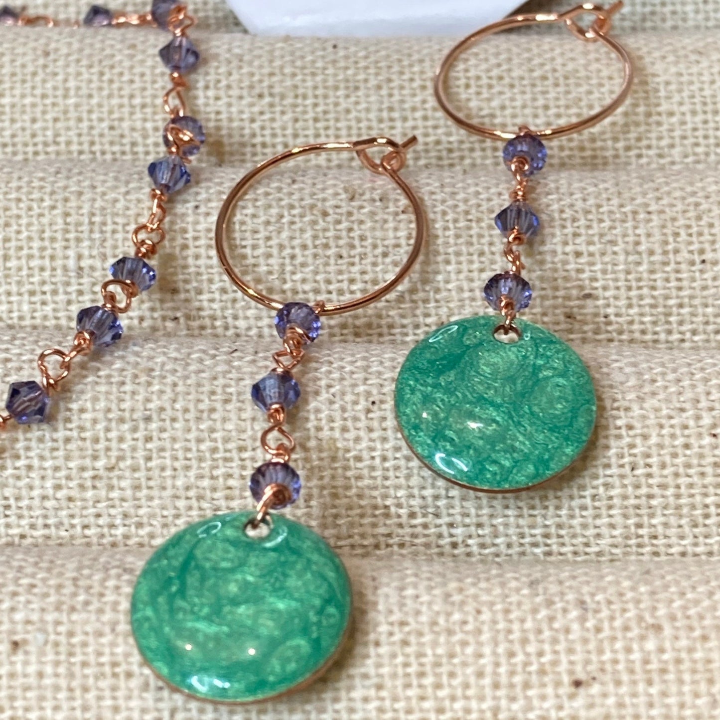 Copper pendant earrings embellished with small crystals.