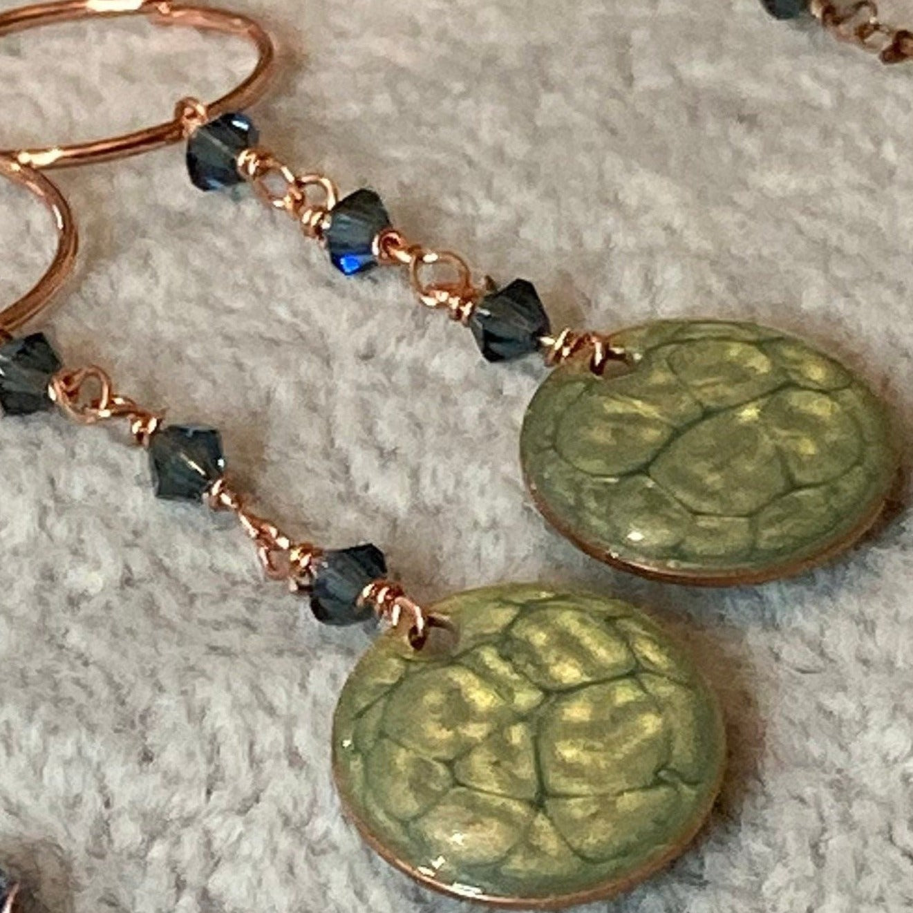 Copper pendant earrings embellished with small crystals.