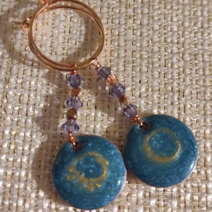 Copper pendant earrings embellished with small crystals.