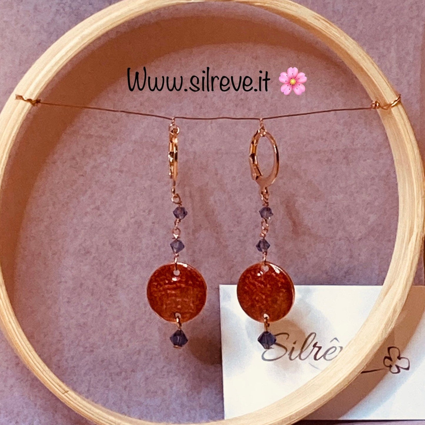 Copper pendant earrings embellished with small crystals.