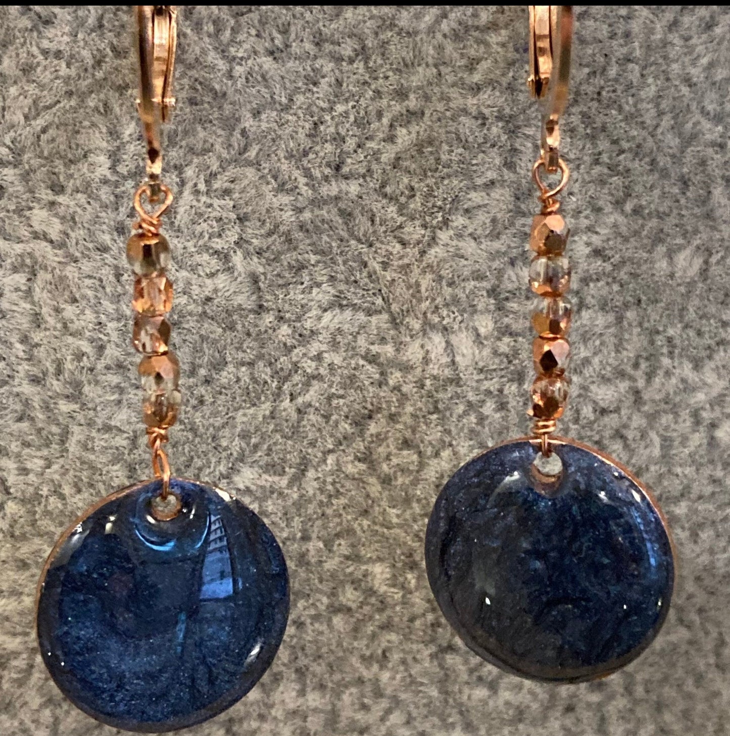 Copper pendant earrings embellished with small crystals.